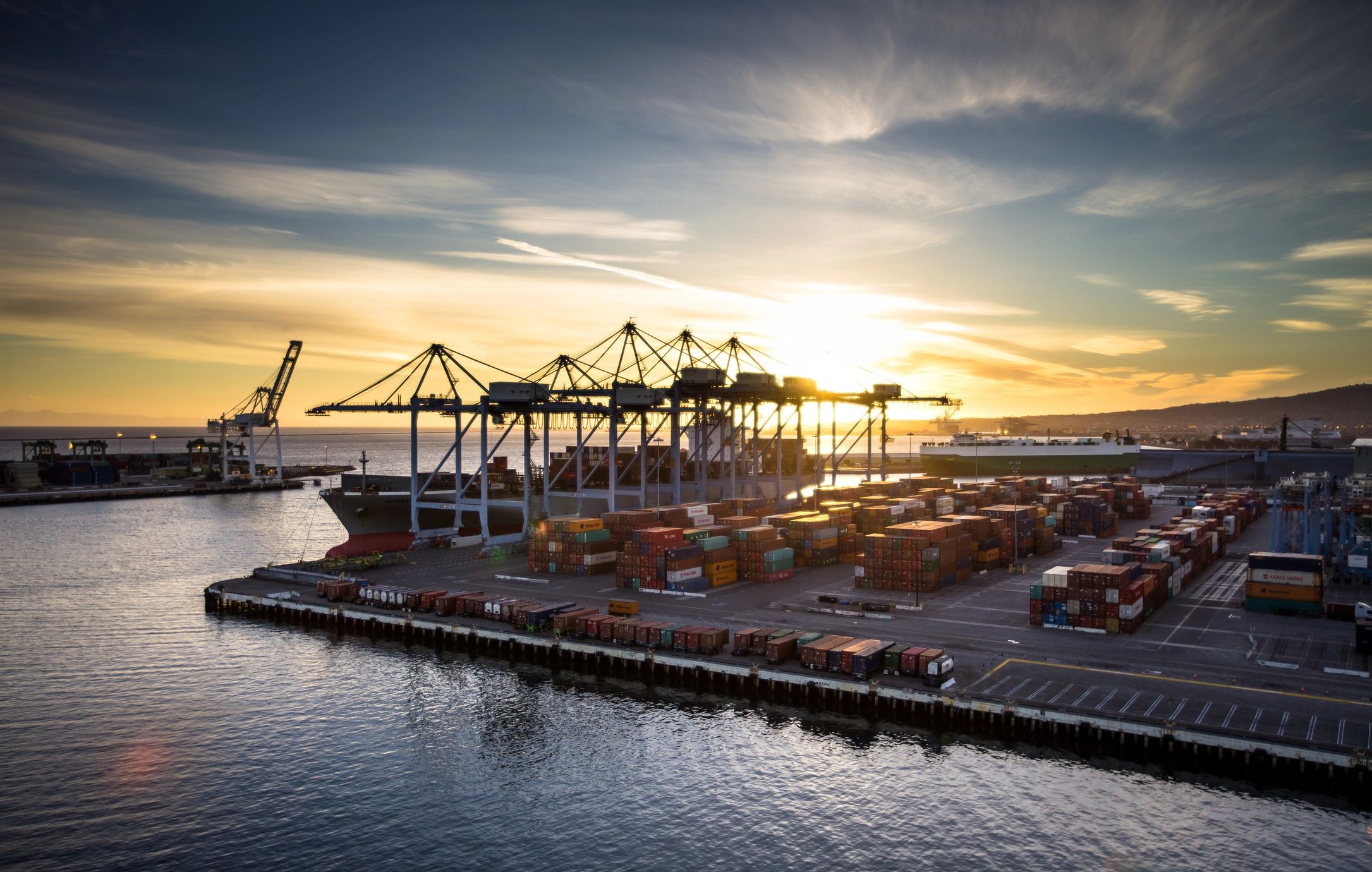 Ship unloading in port at sunset
